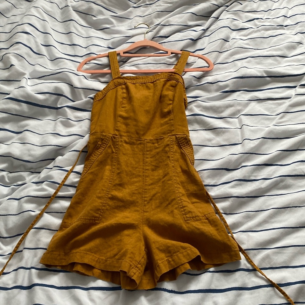 orangeish jumper with adjusting strap and pockets.